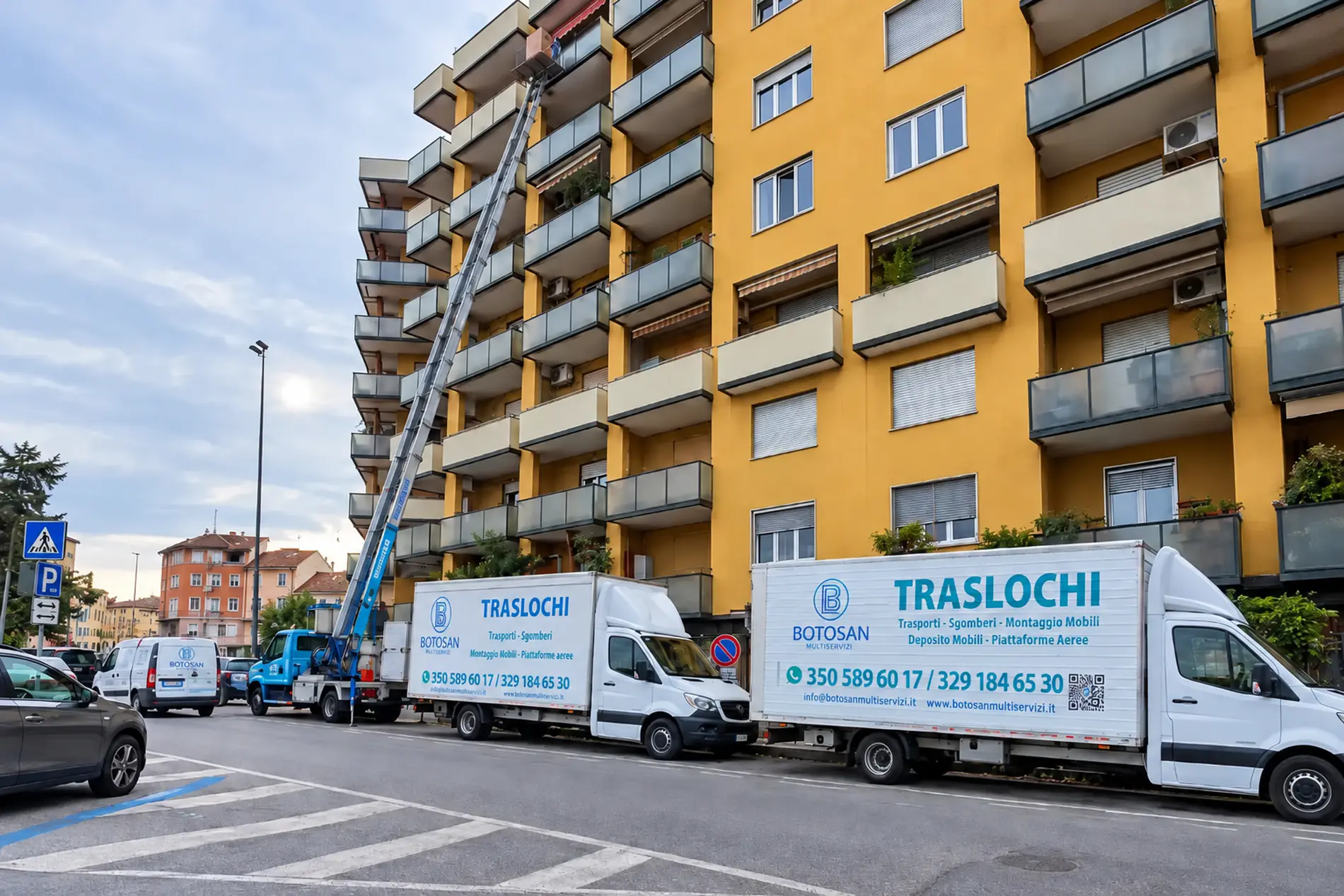 Scala aerea Botosan al lavoro su un palazzo, con due camion dei traslochi in strada